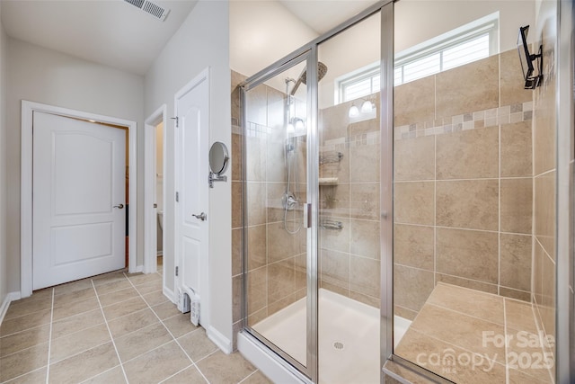 bathroom featuring a shower with shower door and tile patterned floors