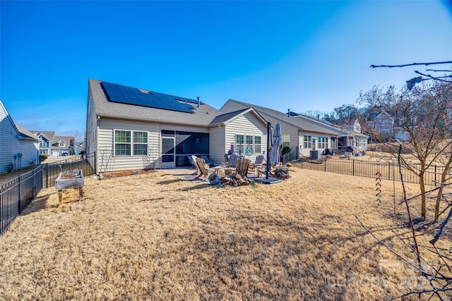 rear view of house featuring a patio and solar panels