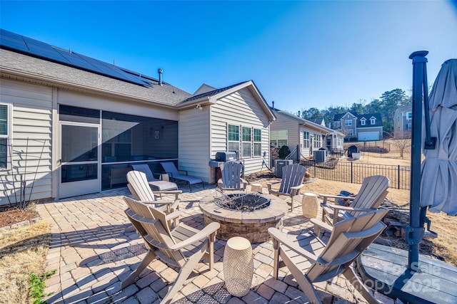 view of patio featuring a fire pit and a sunroom