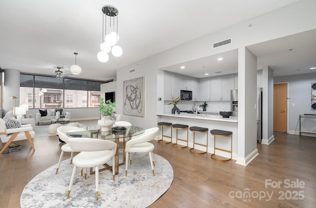 dining space with hardwood / wood-style flooring and ceiling fan