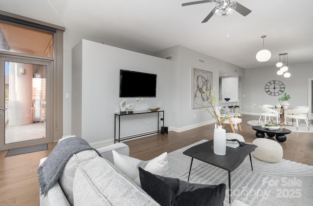 living room featuring ceiling fan and wood-type flooring