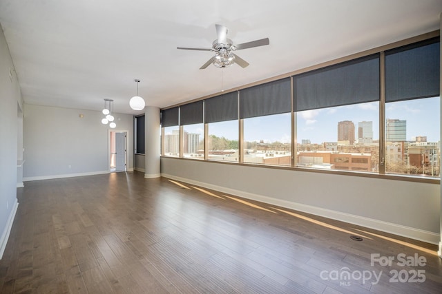 unfurnished room with ceiling fan and dark hardwood / wood-style flooring