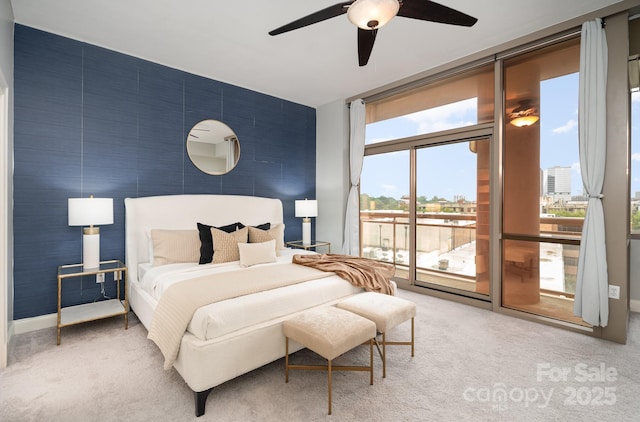 carpeted bedroom featuring expansive windows, access to exterior, and ceiling fan