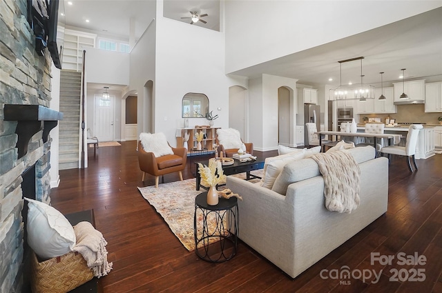 living room with dark hardwood / wood-style flooring, a fireplace, and ceiling fan