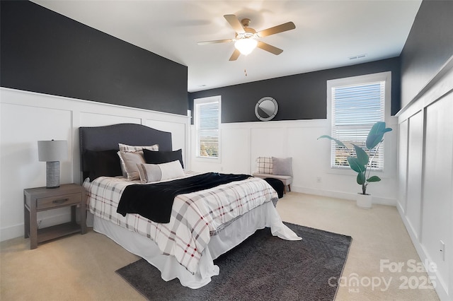 bedroom with ceiling fan and light carpet