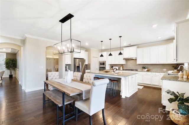 dining area featuring crown molding, dark hardwood / wood-style flooring, a chandelier, and sink