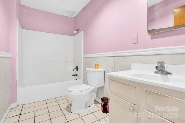 full bathroom with toilet, tile walls, shower / tub combination, vanity, and tile patterned flooring