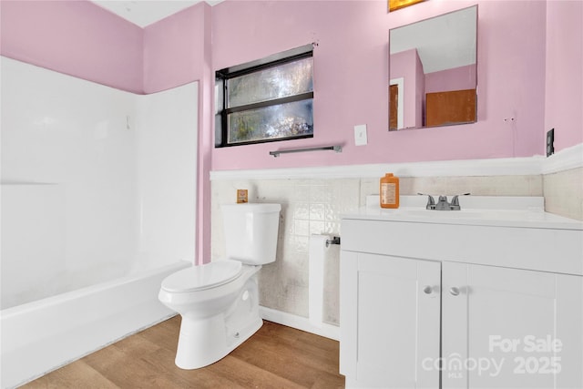 full bathroom with toilet, tile walls, vanity, shower / bath combination, and hardwood / wood-style floors