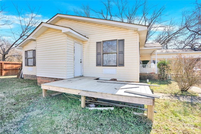 back of property with a yard and a deck