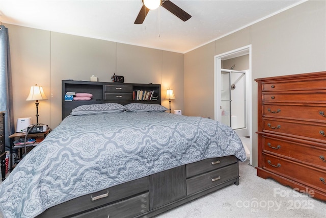 bedroom with ceiling fan, light colored carpet, and ensuite bath