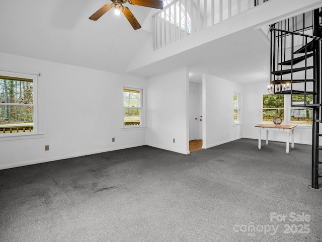 unfurnished living room with dark carpet, high vaulted ceiling, and ceiling fan