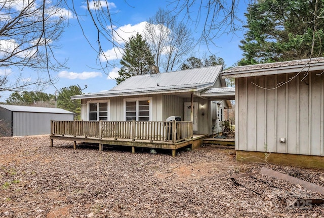 rear view of property featuring an outbuilding and a deck