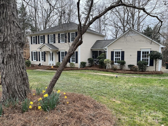 colonial inspired home featuring a front lawn