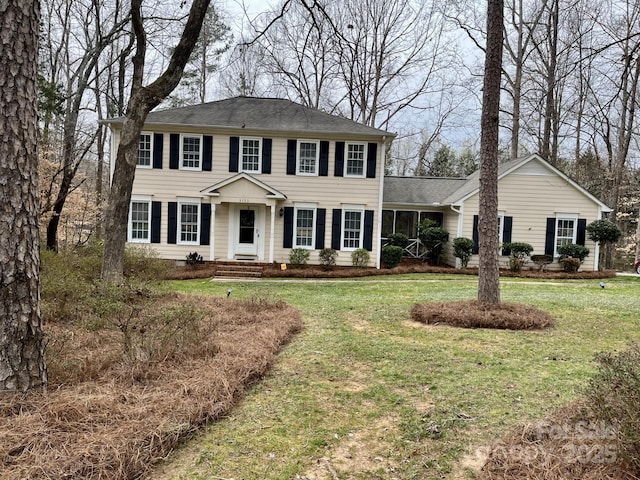 colonial house featuring a front lawn