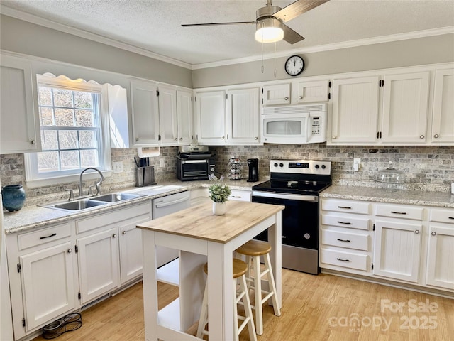 kitchen with light wood-style flooring, a sink, white appliances, white cabinets, and crown molding