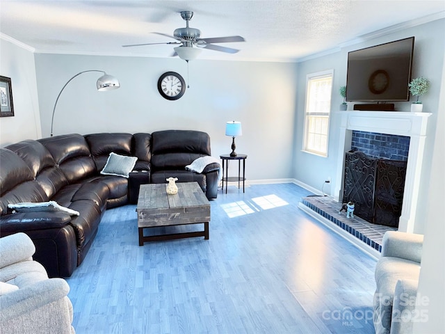 living area with crown molding, a brick fireplace, wood finished floors, and a textured ceiling