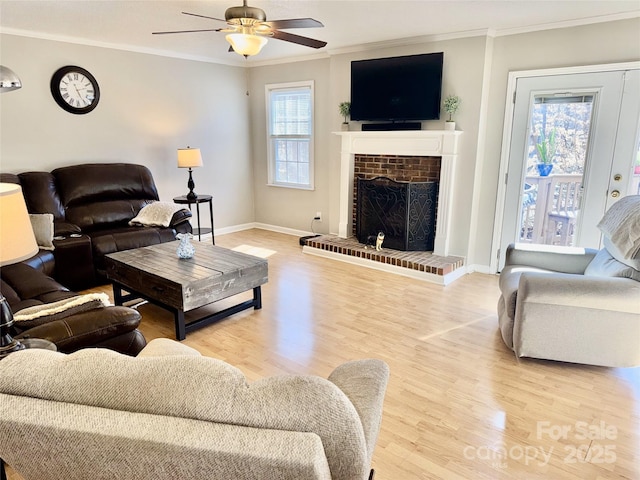 living room featuring a wealth of natural light, light wood-type flooring, and ornamental molding