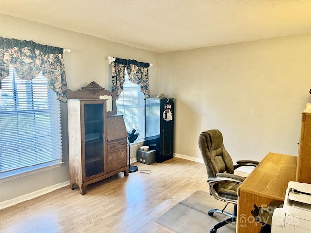 office area featuring wood finished floors, a healthy amount of sunlight, and baseboards