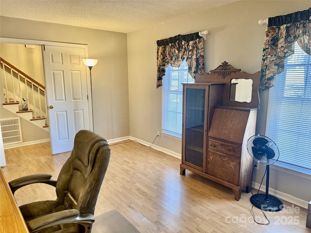 office area featuring visible vents, wood finished floors, baseboards, and a textured ceiling