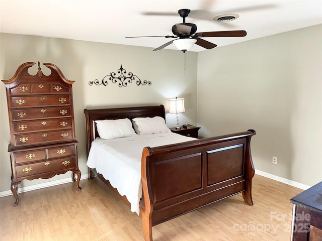 bedroom featuring a ceiling fan, baseboards, visible vents, and light wood-type flooring