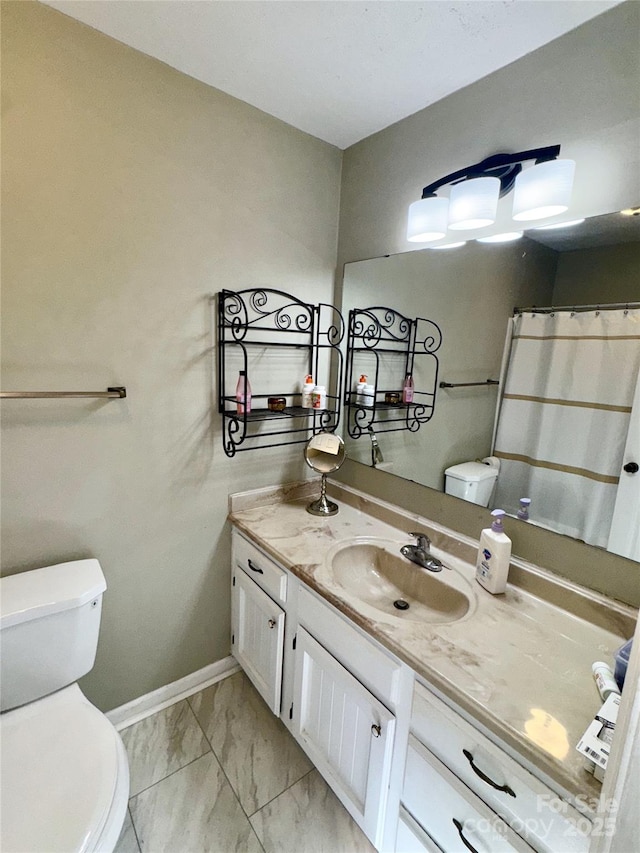 bathroom with baseboards, toilet, marble finish floor, and vanity