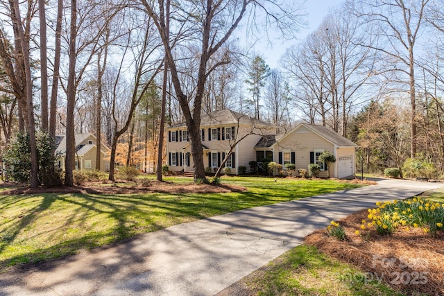 view of front facade with a garage, driveway, and a front lawn