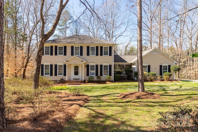 colonial home featuring a front lawn