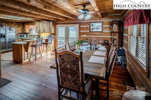 dining room with wood ceiling, ceiling fan, beam ceiling, dark hardwood / wood-style floors, and wood walls