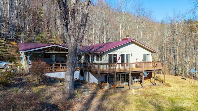 rear view of property with a yard and a deck