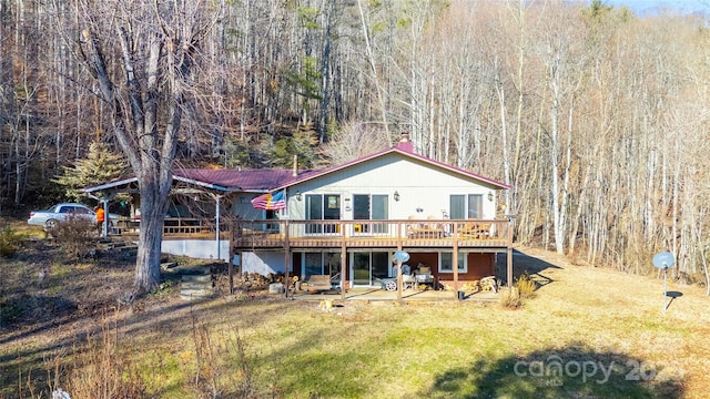 rear view of house with a yard and a deck