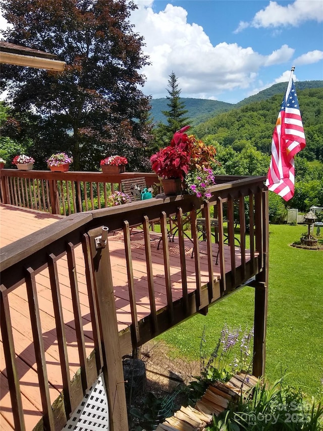 deck with a mountain view and a yard