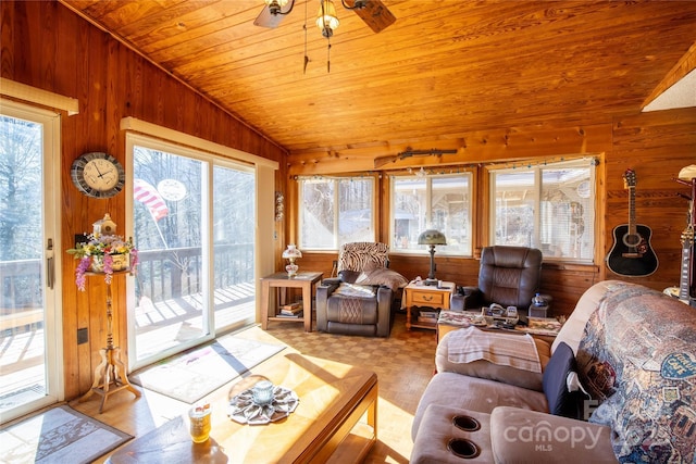 living room with lofted ceiling, wood ceiling, wooden walls, and ceiling fan