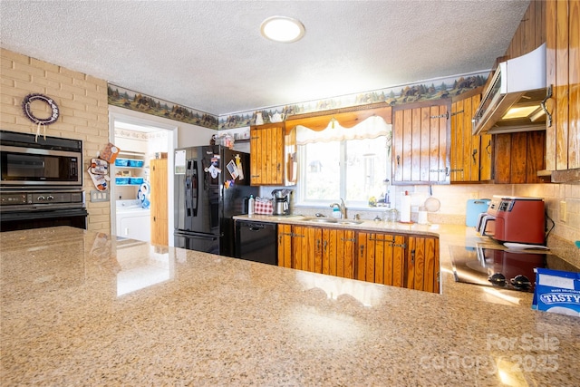 kitchen featuring washer / dryer, sink, ventilation hood, a textured ceiling, and black appliances