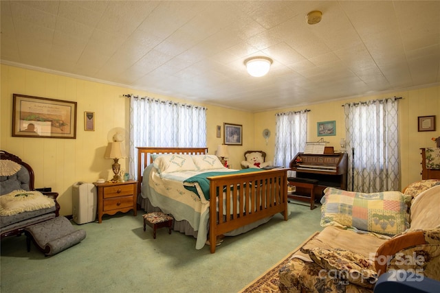 bedroom with ornamental molding and carpet flooring