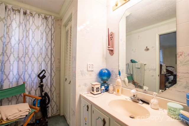 bathroom featuring tile walls, vanity, crown molding, and decorative backsplash