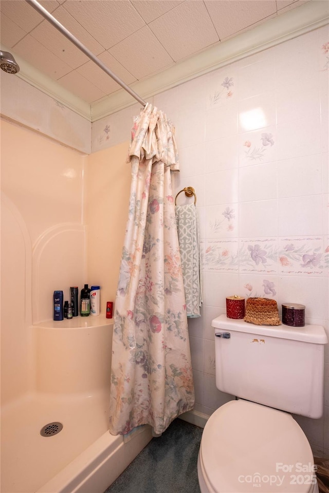 bathroom with toilet, a shower with shower curtain, and tile walls