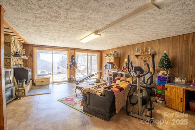 living room with wooden walls and a textured ceiling