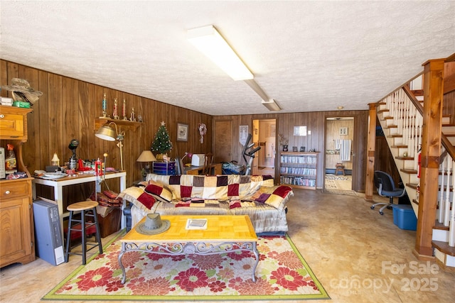 living room with a textured ceiling and wood walls