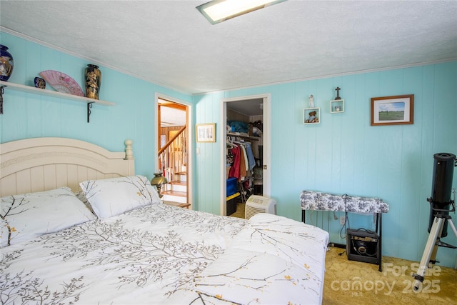 bedroom featuring a closet, a spacious closet, light carpet, and a textured ceiling