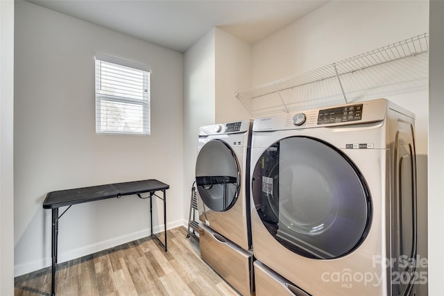 clothes washing area with light hardwood / wood-style floors and washer and dryer