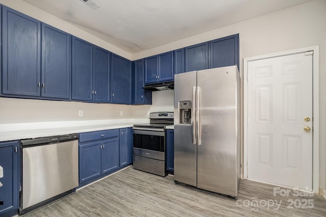 kitchen featuring appliances with stainless steel finishes, blue cabinetry, and light wood-type flooring