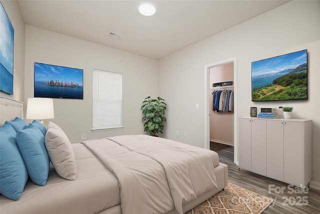 bedroom featuring hardwood / wood-style floors, a spacious closet, and a closet