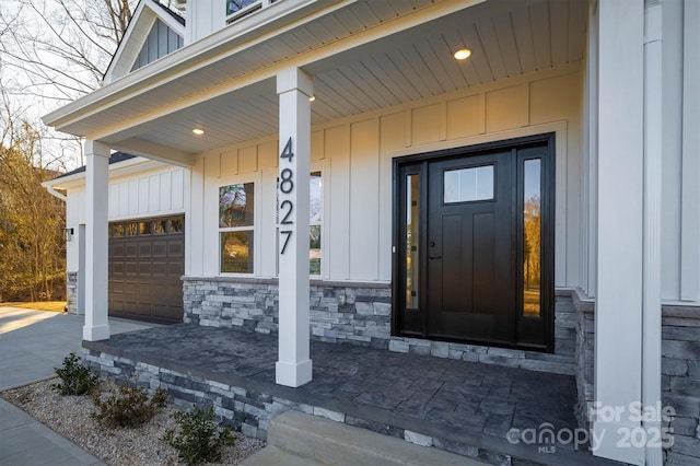 entrance to property with a garage and covered porch