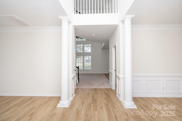 hall featuring ornamental molding and ornate columns