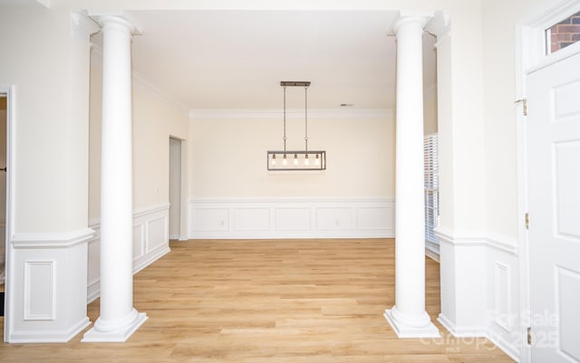 hallway featuring decorative columns, crown molding, and light hardwood / wood-style floors