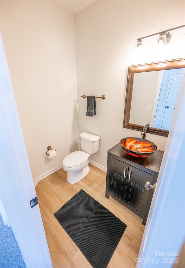 bathroom featuring vanity, toilet, and hardwood / wood-style floors