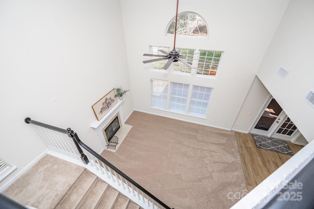 living room featuring a high ceiling, carpet, and ceiling fan