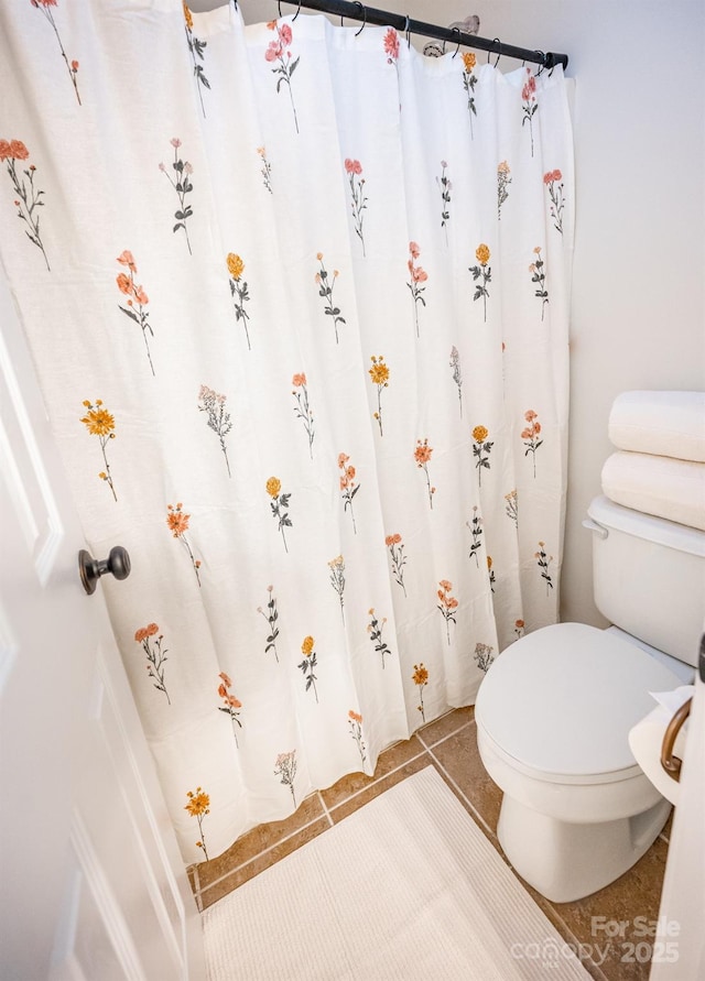 bathroom featuring toilet and tile patterned flooring