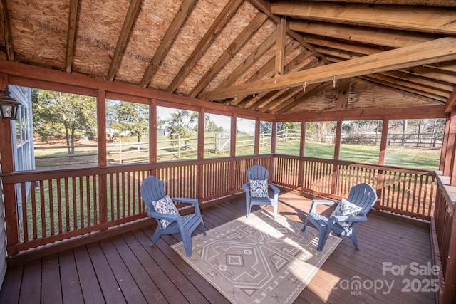 unfurnished sunroom featuring vaulted ceiling