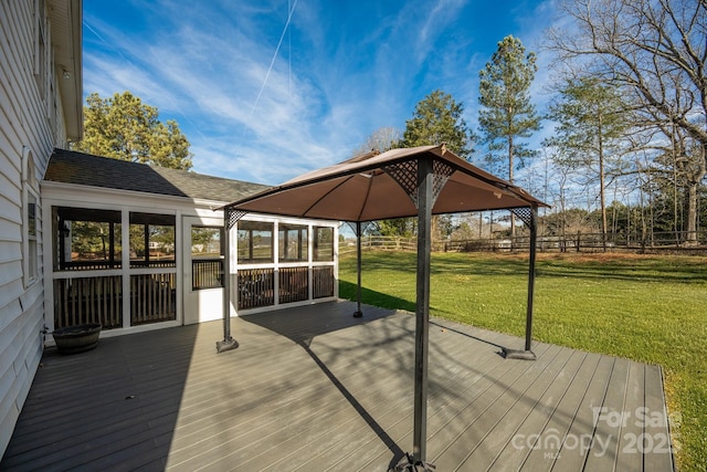 wooden deck featuring a gazebo and a lawn